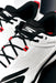Close-up of Skechers Cricket Elite Cricket Shoe, white with black laces, black and red accents, and textured side panels. Designed by Skechers for superior grip on the field.
