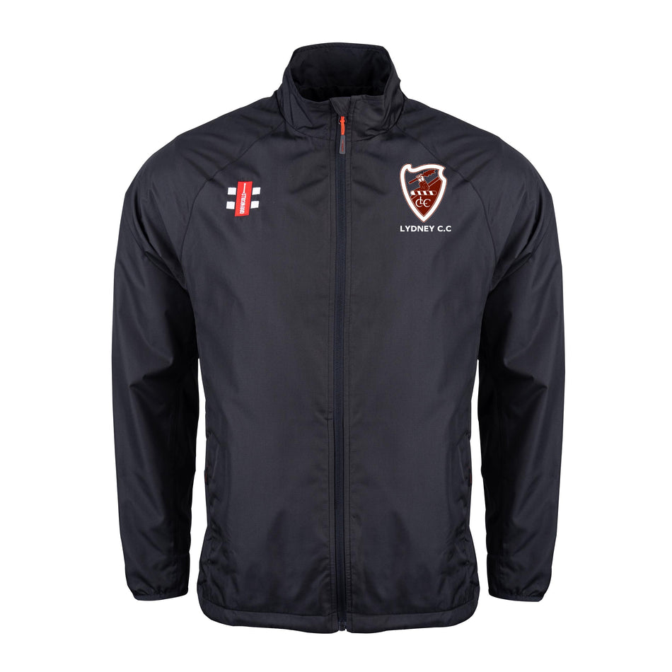 The Gray Nicolls Lydney CC Velocity Rain Jacket is a black, lightweight, water repellent cricket jacket with a stand-up collar, zip front, and two embroidered chest logos: the Lydney C.C. shield and red/black/white vertical emblem.
