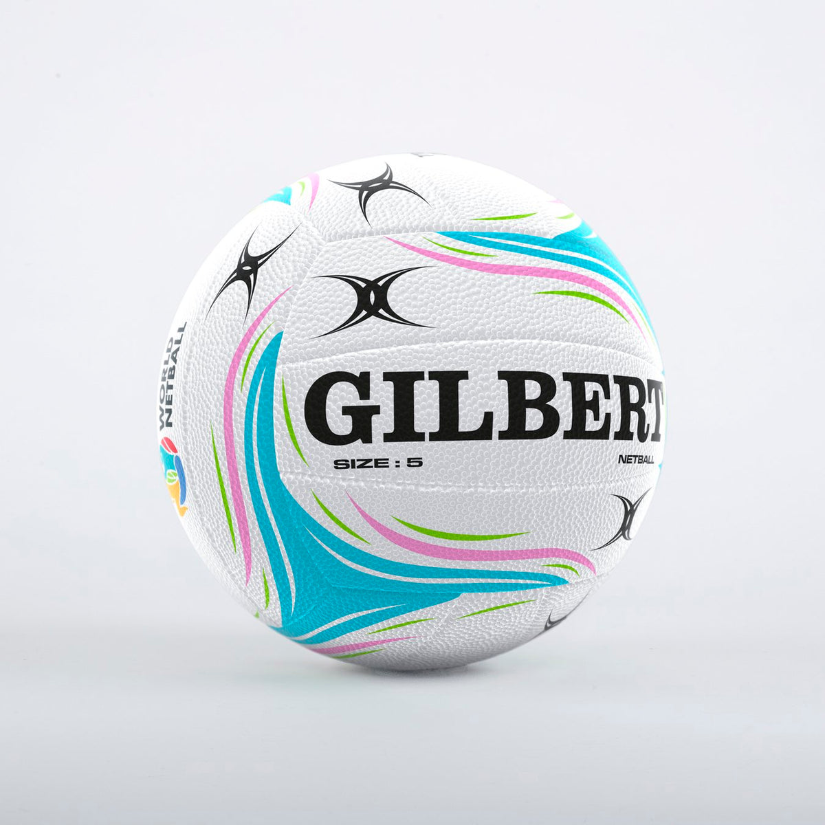 The Gilbert Aurora Match Netball by Gilbert is a size 5 white ball with blue, green, and pink curves, black star patterns, and fused rubber construction, displayed on a plain light background.