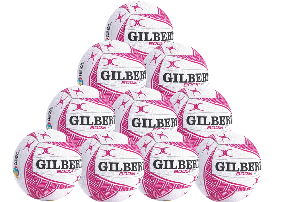 A pyramid stack of ten white and pink Gilbert Boost Match Netballs in four tiers, each with the GILBERT brand name clearly visible.
