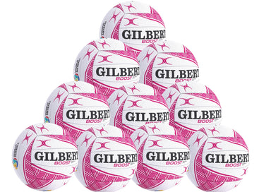 A pyramid stack of ten white and pink Gilbert Boost Match Netballs in four tiers, each with the GILBERT brand name clearly visible.