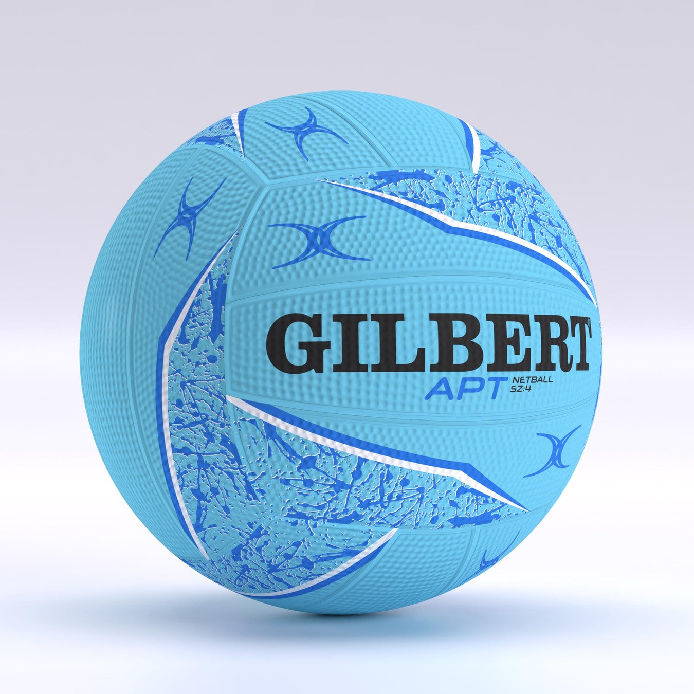 The Gilbert APT 2026 Netball is light blue with dark blue and white patterns, Duragrip texture for control, bold Gilbert branding, and smaller APT Netball text. The ball appears against a plain, light background.