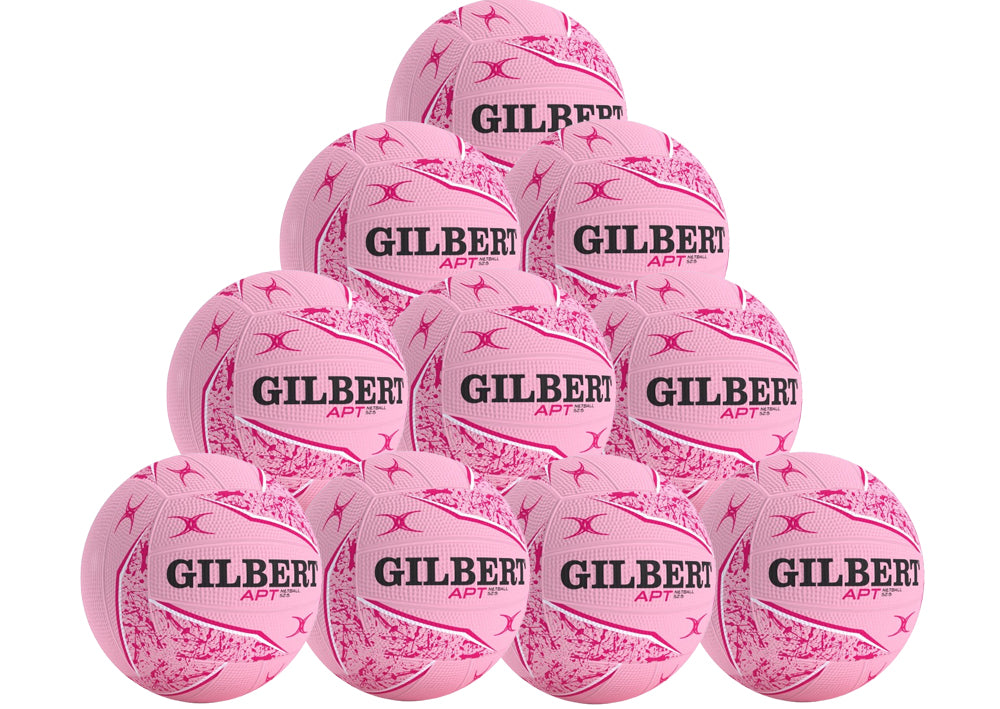 A pyramid stack of ten pink Gilbert APT 2026 netballs with black text and patterns, displayed on a white background. From Gilbert, this netball pack is ideal for team or school outdoor training.