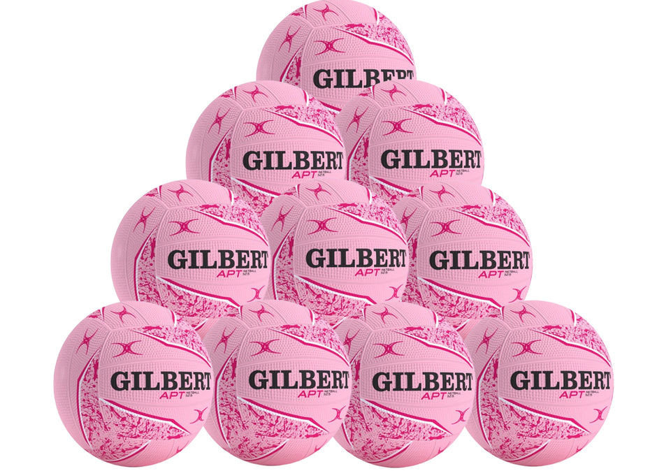 A pyramid stack of ten pink Gilbert APT 2026 netballs with black text and patterns, displayed on a white background. From Gilbert, this netball pack is ideal for team or school outdoor training.