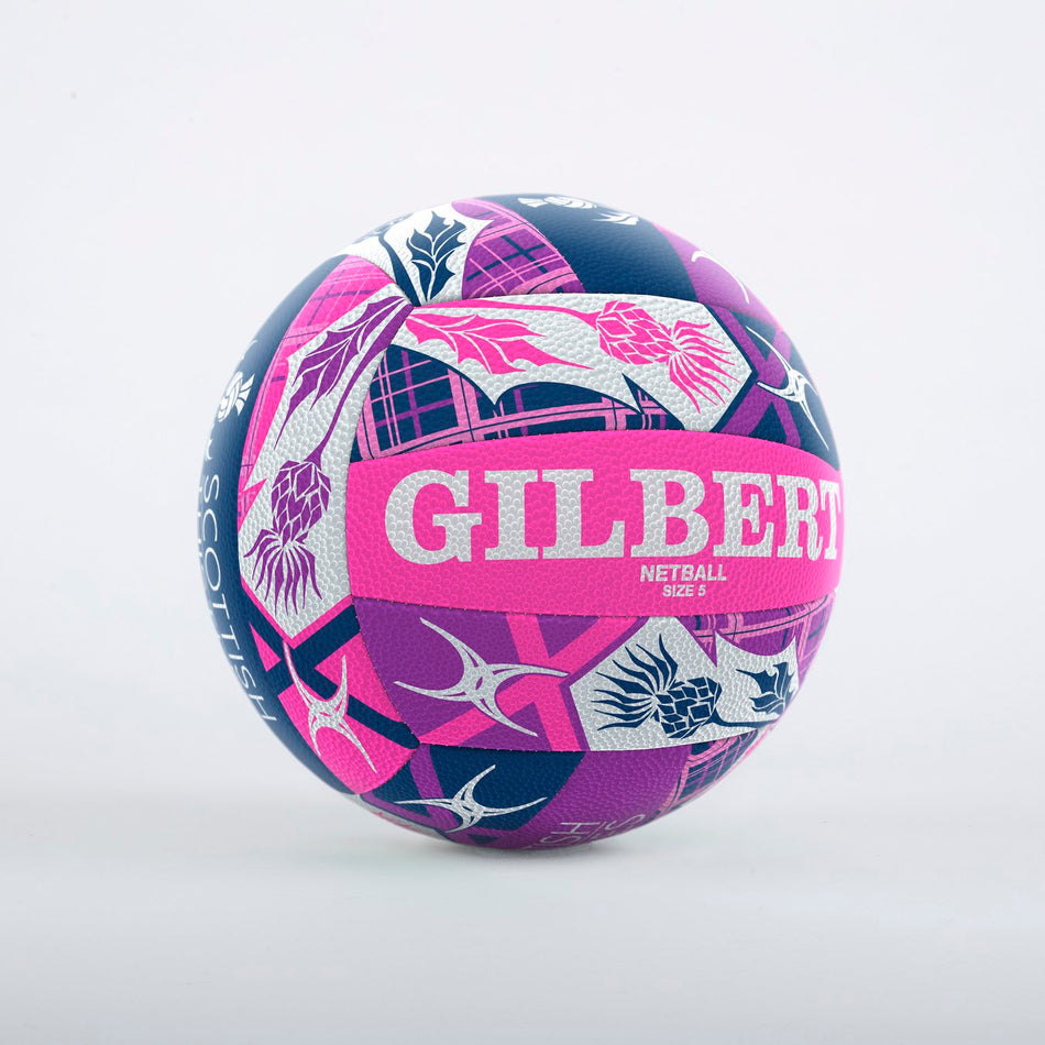 The Gilbert Scotland Supporter Netball is a vibrant Size 5 ball featuring bold pink, purple, and navy geometric and floral designs, with "GILBERT" displayed prominently in large white letters.