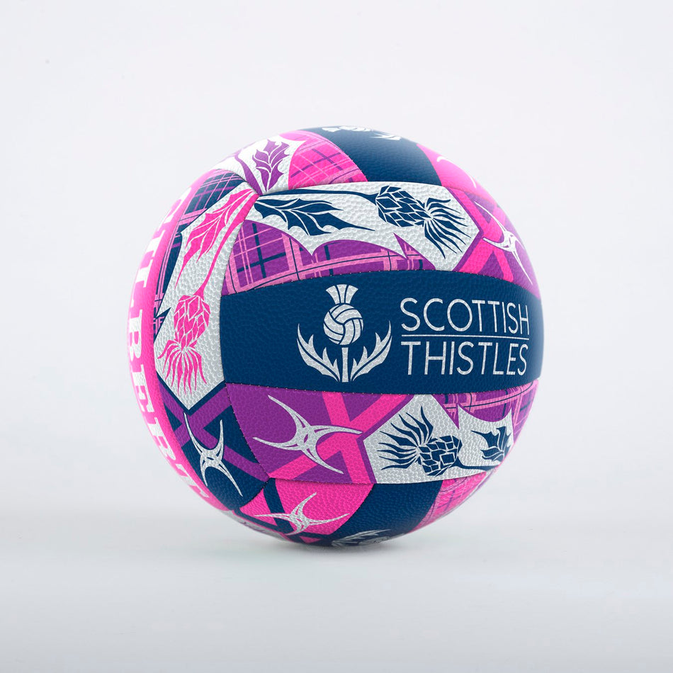 The Gilbert Scotland Supporter Netball is a colorful Size 5 ball with blue, pink, and white geometric and floral designs, “Scottish Thistles” text, a thistle logo, and Duragrip for control—perfect for Scotland fans.