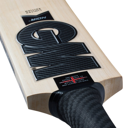 Close-up of the Gunn & Moore Noir DXM Senior Cricket Bat 2026, featuring a black grip, bold NOIR branding, carbon fiber texture, and smooth light English Willow blade—perfect for the upcoming cricket season.