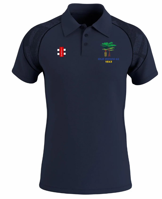 The Gray Nicolls Old Down CC GTS Men’s Polo Shirt in navy blue features a collared design, embroidered tree and Old Down CC 1843 logo, a red-and-white accent, stylish black patterned shoulders, and quick-dry moisture-wicking comfort.