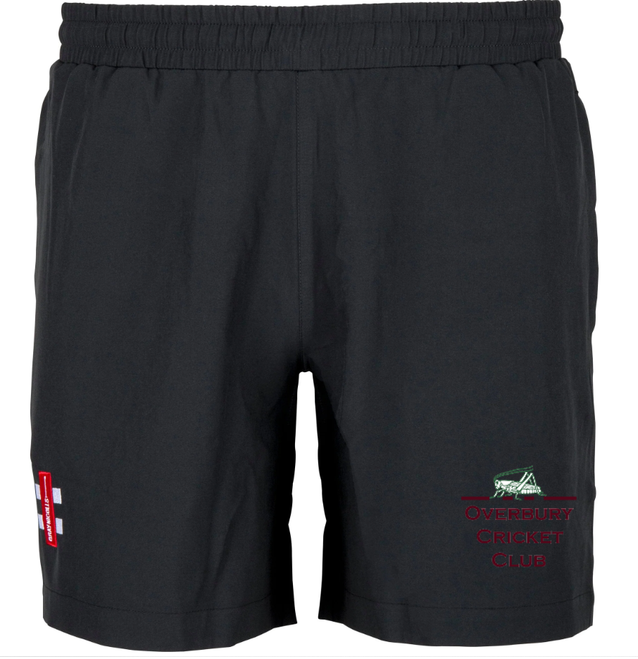 Gray Nicolls Overbury CC Velocity Training Shorts: black athletic shorts with elastic waistband, left leg red and white patch, right leg embroidered green grasshopper and "Overbury Cricket Club" in red—ideal for training or matches.