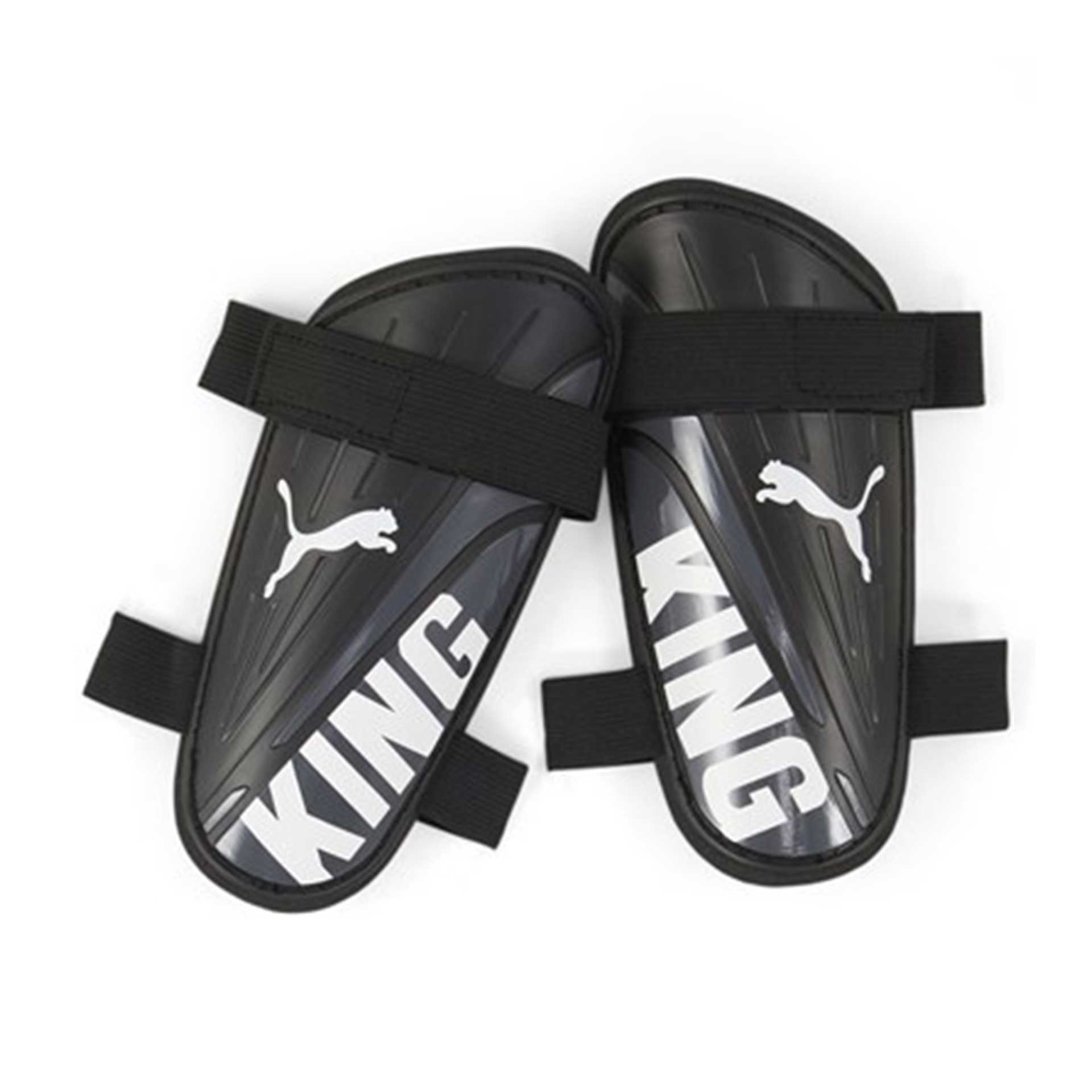The Puma King Strap Shin Guard by Puma features black guards with white logos and "KING" text, plus black elastic straps for a secure fit, delivering reliable shin protection during soccer matches.