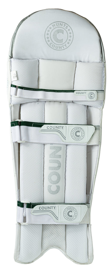 The Hunts County Triumph Batting Pads are white, ambidextrous pads with multiple straps and stitched detailing. Designed for club cricketers, they feature reinforced padding and the Hunts County brand for optimal protection.
