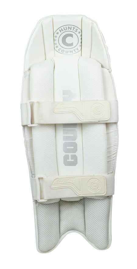 The Hunts County Platinum Wicket Keeping Pads are lightweight, test-level white pads with "Hunts County" in gray, two padded straps, and a textured protective surface, shown on a white background.