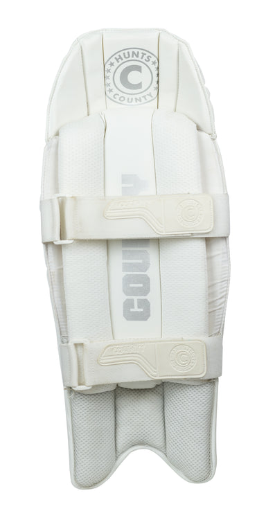 The Hunts County Platinum Wicket Keeping Pads are lightweight, test-level white pads with "Hunts County" in gray, two padded straps, and a textured protective surface, shown on a white background.