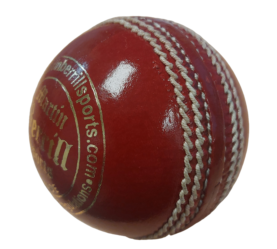 A close-up of the shiny red MBS Platinum Crown Cricket Ball by Martin Berrill Sports, featuring visible white stitching and gold text on its surface, displayed against a white background.