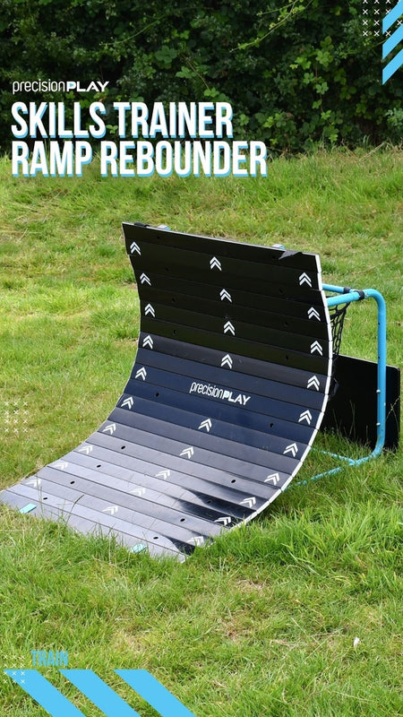 A curved black and blue Precision Training PrecisionPLAY Skills Trainer Ramp Rebounder sits on grass, ideal for sports training as a ramp rebounder or passing board. "Skills Trainer Ramp Rebounder" text is displayed above.