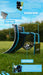 The Precision Training PrecisionPLAY Skills Trainer Ramp Rebounder sits on grass, featuring a curved ramp, passing rebound board, and catch basket with labeled callouts for passing and ball control drills.