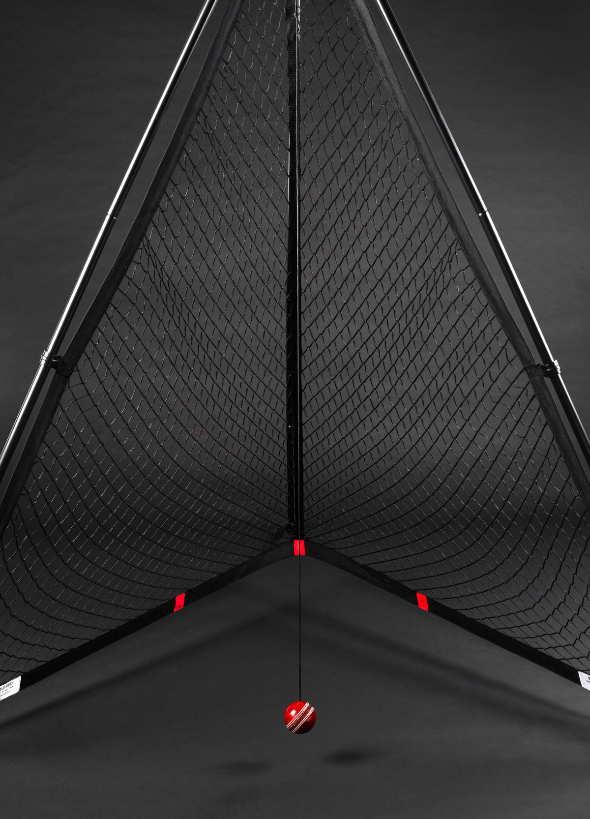 The V Pro 2.0 by The V features a triangular black frame training net with a suspended red and white striped cricket ball, ideal for batting practice and skill improvement.