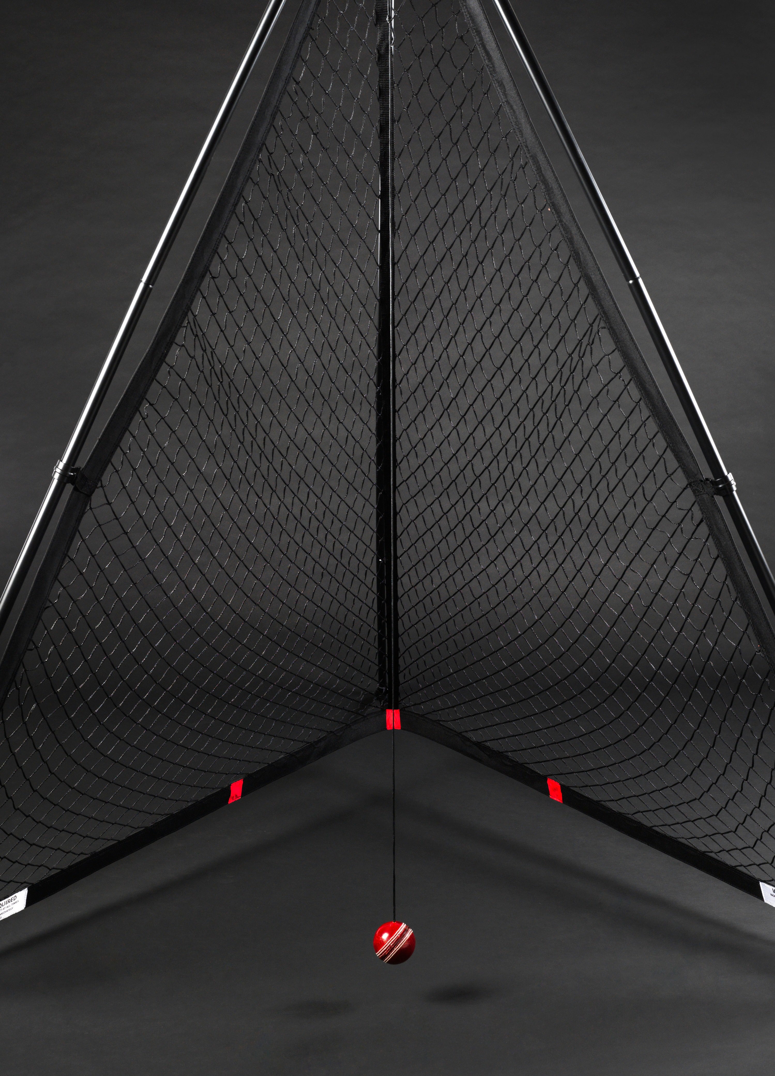 The V Pro 2.0 by The V features a triangular black frame training net with a suspended red and white striped cricket ball, ideal for batting practice and skill improvement.