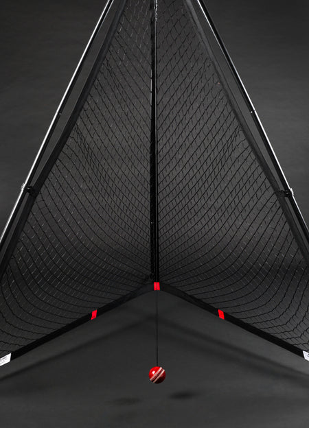 The V Pro 2.0 by The V features a triangular black frame training net with a suspended red and white striped cricket ball, ideal for batting practice and skill improvement.