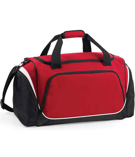The Quadra Pro Team Holdall by Quadra is a 55L gym bag in red/black/white, featuring black handles, a shoulder strap, white trim, a large front pocket, side pockets, zippered main compartment, and a shoe tunnel for convenience.