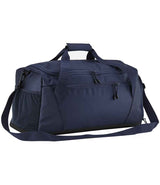 The Quadra Multi-Sport Locker Holdall by Quadra is a navy duffel bag made from recycled polyester, featuring a top handle, adjustable shoulder strap, side pocket, front zippered compartments, and a dedicated racquet pocket on a white background.