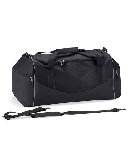 The Quadra Teamwear Holdall by Quadra, shown in Black/Black/Grey, features a padded hand grip, multiple zippered compartments, large end pockets, and a detachable adjustable shoulder strap against a plain white background.