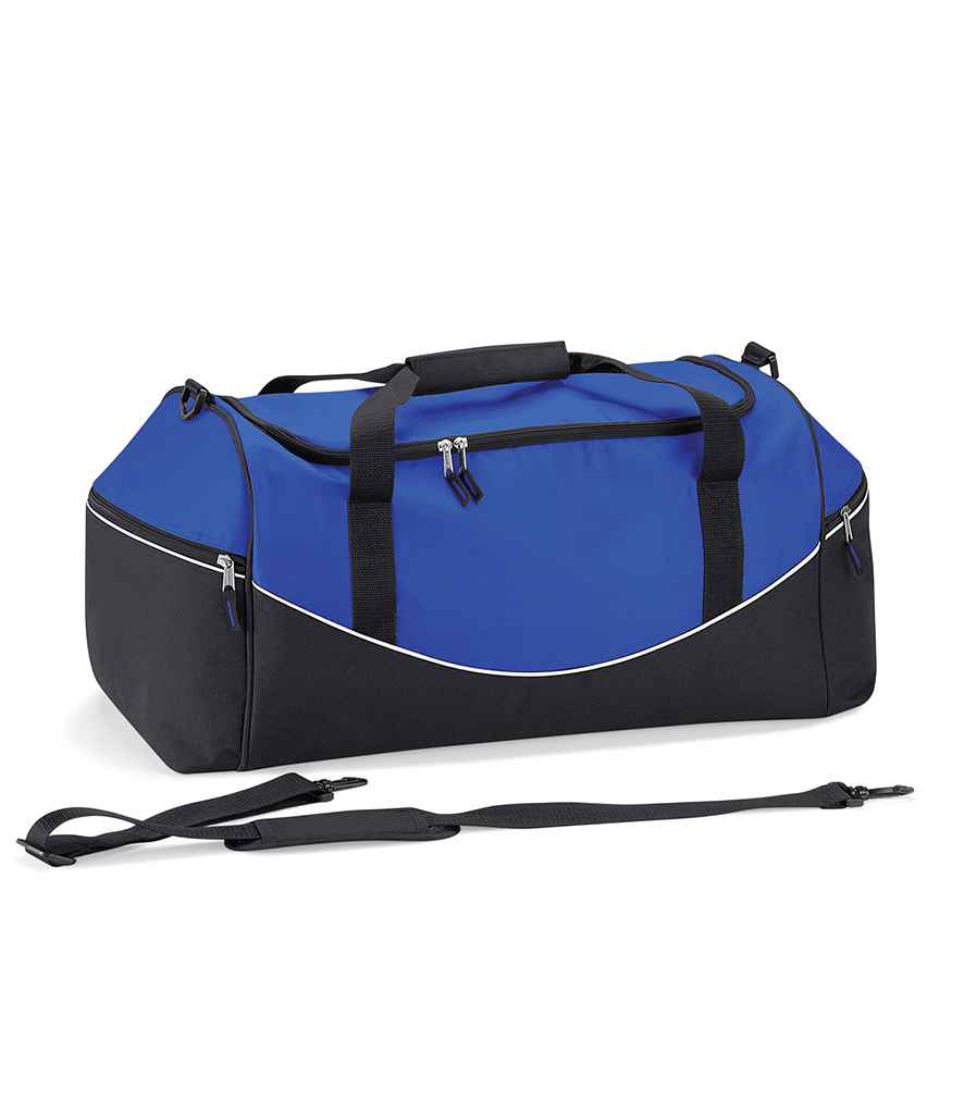 The Quadra Teamwear Holdall by Quadra is shown in royal blue/black/white with black handles, zippers, a detachable shoulder strap, curved white piping, padded hand grip, multiple zippered compartments, and large end pockets.