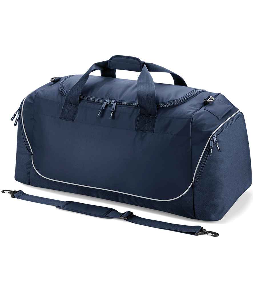 The Quadra Teamwear Jumbo Kit Bag by Quadra in French Navy/Light Grey features large capacity, multiple zippered compartments, two handles, an adjustable shoulder strap in front, and sleek white piping accents.