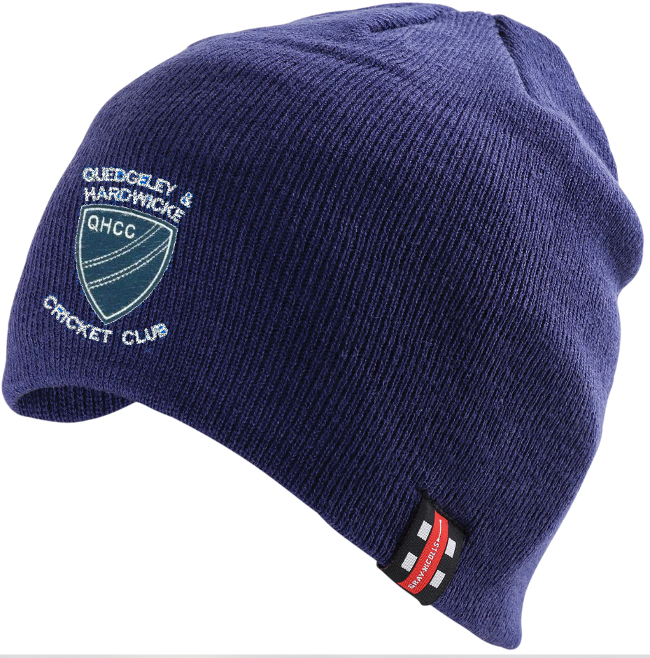 The Quedgeley & Hardwicke CC Beanie Hat by Gray Nicolls is a navy beanie with the Q&H CC logo embroidered on the front and a small black, red, and white tag on the edge.