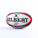 The Gilbert Orion Match Rugby Ball by Gilbert, in black/red, features bold logos and text. Hand stitched and designed for official World Rugby matches, it’s displayed on a plain white surface with a white background.