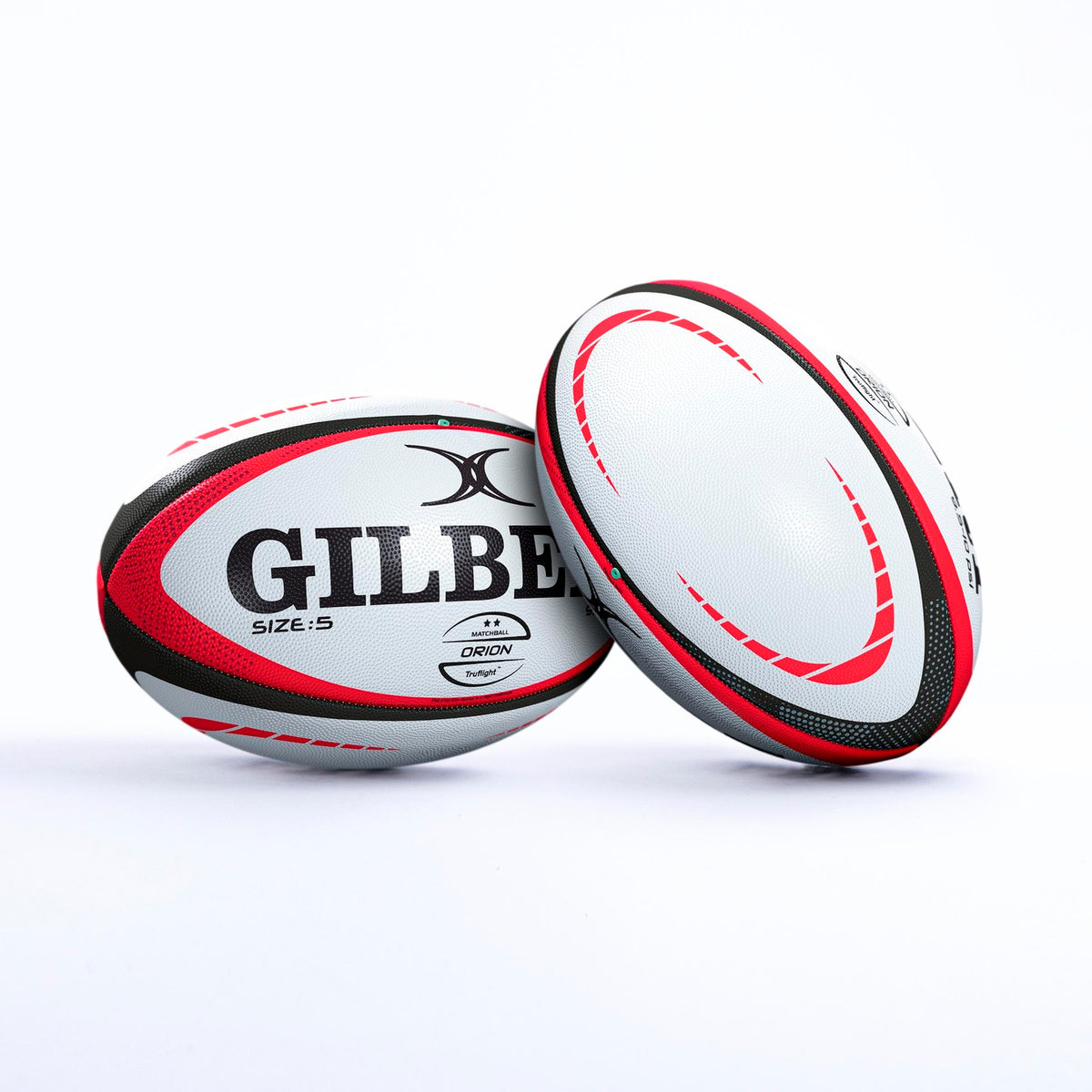 Two white Gilbert Orion Match Rugby Balls, hand stitched with red and black patterns, display the Gilbert brand, World Rugby logo, and size 5 label. Set on a plain white background, one ball is upright while the other leans against it.