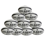 Ten black Gilbert G-TR4000 Rugby Balls from Gilbert are stacked in a pyramid shape against a white background, each branded with “GILBERT” and featuring Tri Grip Technology. Available as a convenient ten pack.