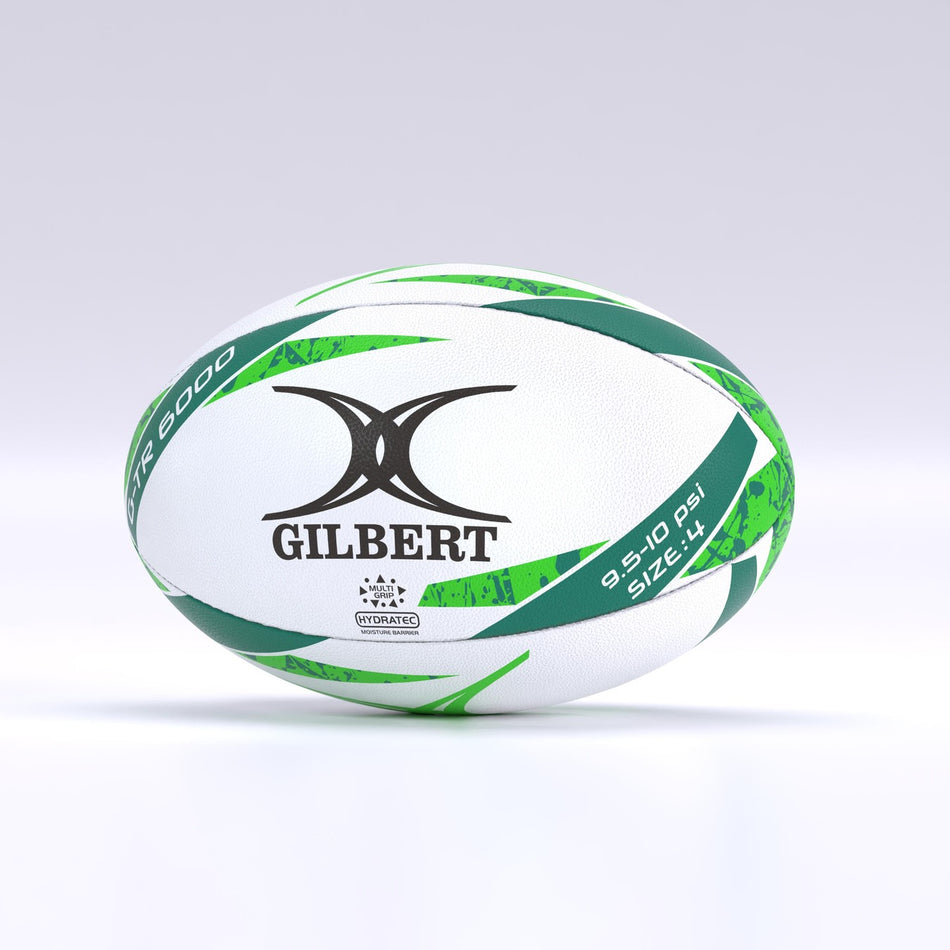 The Gilbert G-TR6000 Training Rugby Ball, a white ball with green and black patterns, durable rubber surface, and size 5 (9.5-10 PSI) markings—ideal for schools and clubs—rests on a plain light background.
