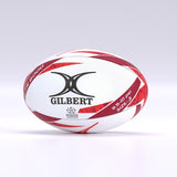 The Gilbert G-TR6000 Training Rugby Ball by Gilbert features a white and red design with black branding, a durable rubber surface, and rests on a smooth surface—ideal for schools and clubs.