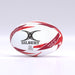 The Gilbert G-TR6000 Training Rugby Ball by Gilbert features a white and red design with black branding, a durable rubber surface, and rests on a smooth surface—ideal for schools and clubs.