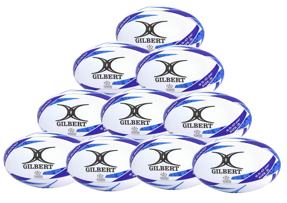 A pyramid of ten Gilbert G-TR6000 Training Rugby Balls, featuring white with blue accents and visible Gilbert branding, is displayed against a plain white background.