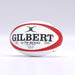 A red Gilbert G-TR8000 Training Rugby Ball is displayed on a plain, light-gray background. The durable rubber ball features black and red branding, as well as size and pressure details printed on its surface.