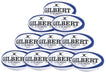 Ten navy Gilbert G-TR8000 Training Rugby Balls from the Gilbert brand are stacked in a pyramid, each displaying the logo—an ideal set for any UK rugby enthusiast.