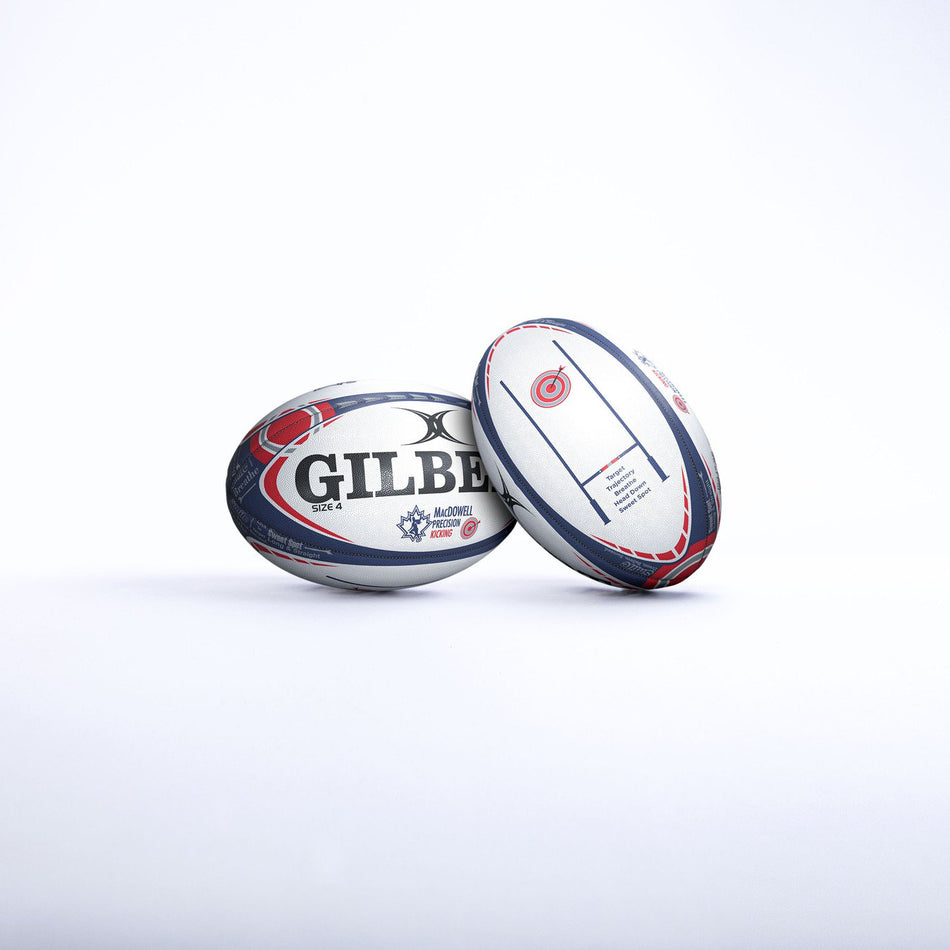 Two rugby balls, both with white, red, and blue designs, stand on a white surface. One is the Gilbert MacDowell Kicking Ball by Gilbert; the other is a Precision Kicking Ball for practicing goalkicking fundamentals.
