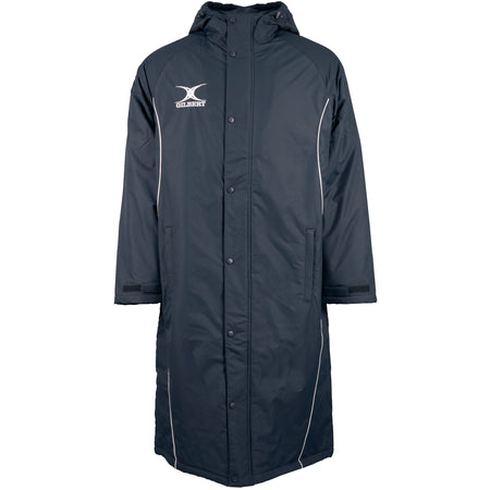 The Gilbert Touchline Sub Jacket by Gilbert is a long, dark waterproof jacket with a hood, button closure, white piping, and an ODIN AQUATIC fish logo—perfect for outdoor wear and inspired by classic touchline style.