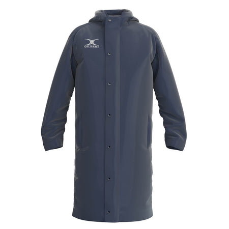 The Gilbert TTS Touchline Jacket is a long, dark navy waterproof coat with a hood, snap-button front, two side pockets, and the Gilbert logo on the chest.
