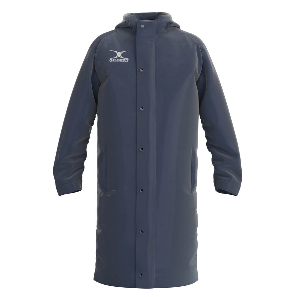 The Gilbert TTS Touchline Jacket is a long, dark navy waterproof coat with a hood, snap-button front, two side pockets, and the Gilbert logo on the chest.