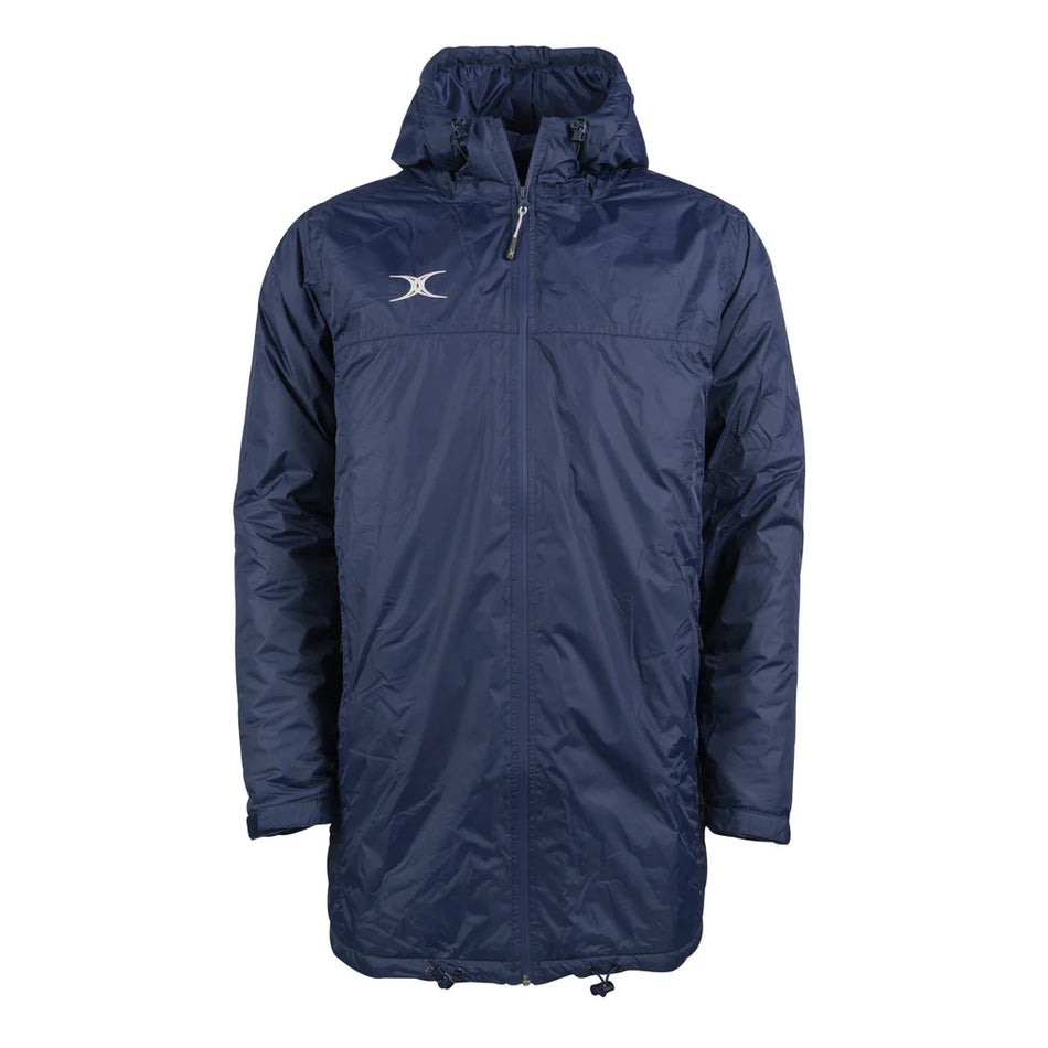 The Gilbert TTS All Weather Jacket by Gilbert is a dark navy, hooded, long waterproof jacket made from recycled polyester with a front zipper, side pockets, adjustable drawstring hem, and a white logo on the left chest.