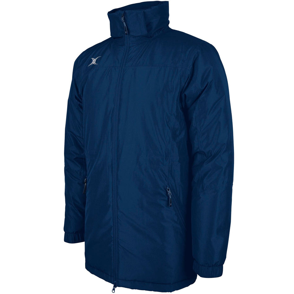 The Gilbert Pro All-Weather Jacket by Gilbert is a navy zip-up with long sleeves, high collar, two zippered side pockets, and a small white logo on the right chest.