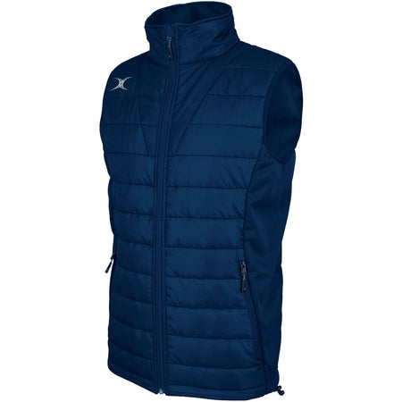 The Gilbert Pro Body Warmer by Gilbert is a sleeveless, navy quilted vest with a high collar, front zipper, two zippered pockets, and a small white logo on the upper left chest. Made from breathable technical fabric.