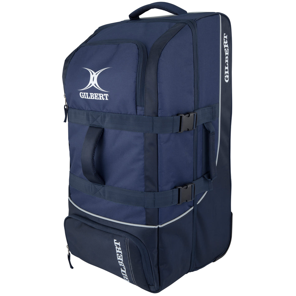 The navy Gilbert Club Tour Wheeled Holdall sports bag features a white logo, two handles, zippered compartments, adjustable straps, and wheels for easy transport of sports equipment.
