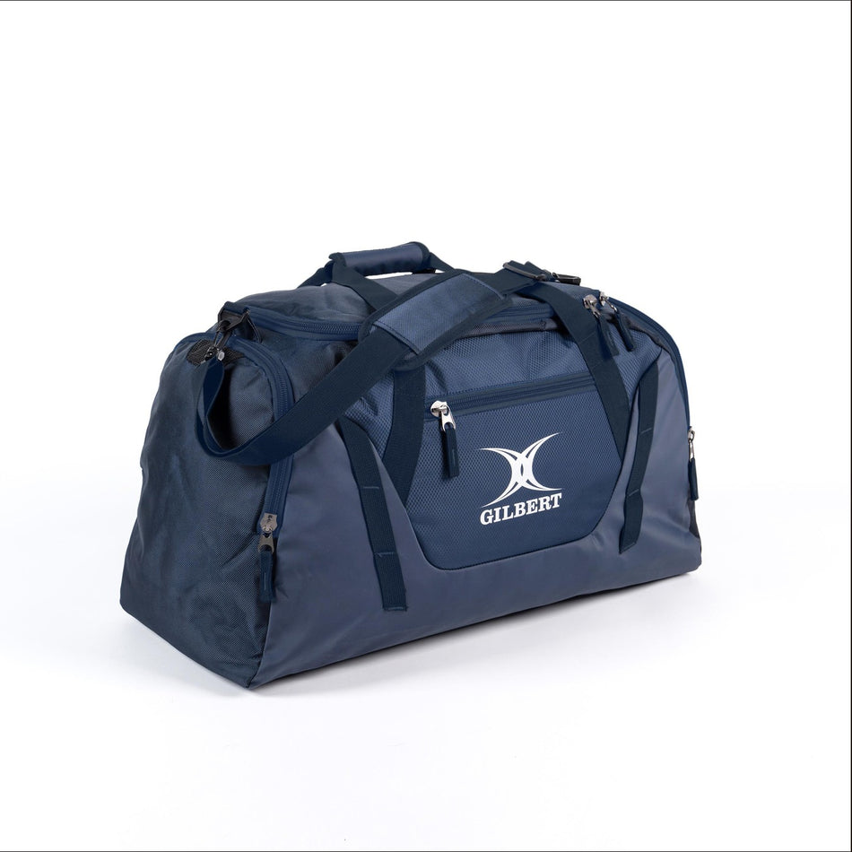 The Gilbert Club V4 Holdall is a spacious navy sports bag with handles, a shoulder strap, multiple zippered pockets, and the white Gilbert logo—ideal for carrying all your rugby gear.