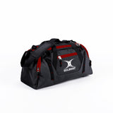 The Gilbert Club Players V4 Holdall by Gilbert in Black/Red features multiple zippered pockets, a shoulder strap, and the iconic GILBERT logo—an ideal durable sports holdall for any rugby player's bag collection.