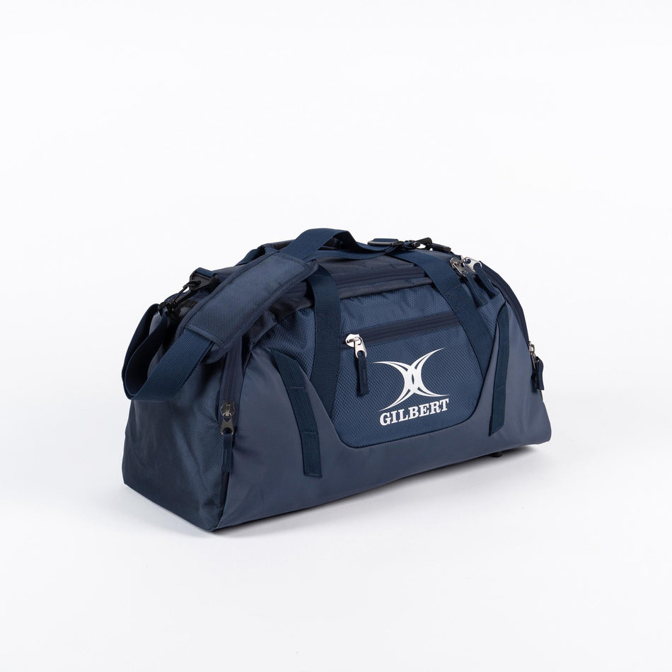 The Gilbert Club Players V4 Holdall is a navy sports duffel bag with multiple zippers, handles, and a shoulder strap. Featuring the Gilbert logo on the front, it's a durable choice for any rugby player's bag collection.