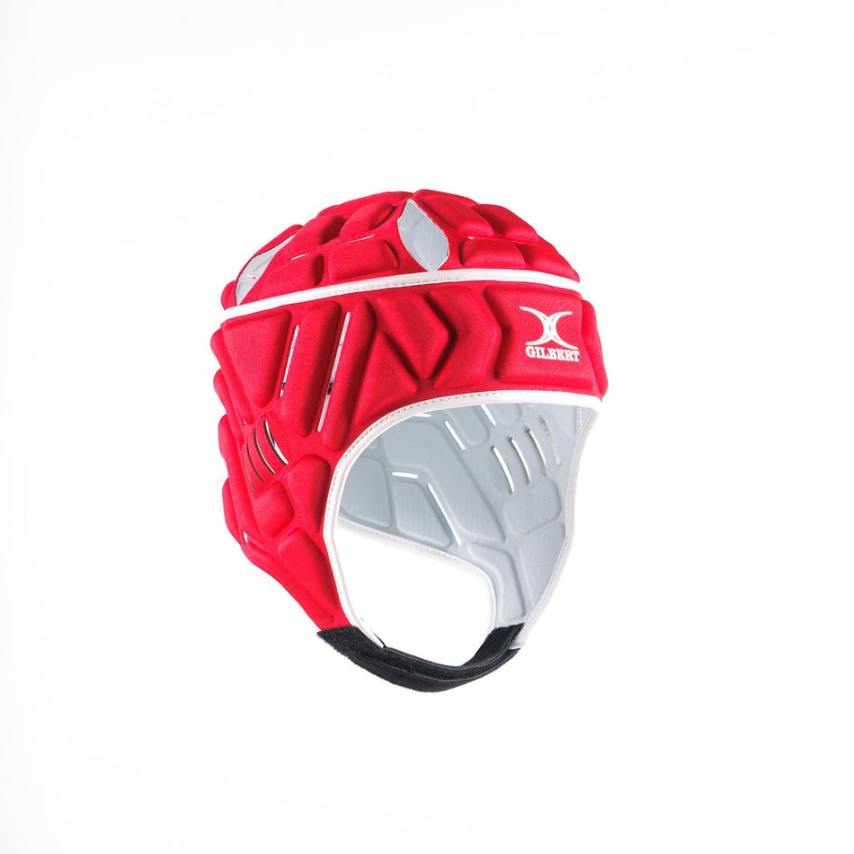 The Gilbert Vapour Senior Headguard by Gilbert is a red padded rugby headguard featuring white and grey accents, a chin strap, and ventilation holes for breathability and impact absorption, shown against a plain white background.